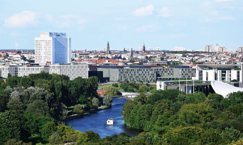 River by cityscape against sky