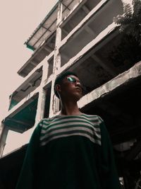 Low angle portrait of man standing against sky