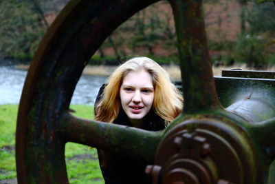 Woman standing behind rusty gear