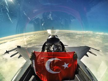 Pilot holding turkish flag while sitting in fighter plane