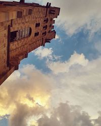 Low angle view of building against cloudy sky