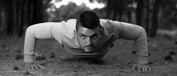 Portrait of young man exercising on land