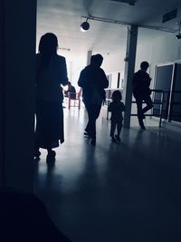 Rear view of silhouette people walking in building