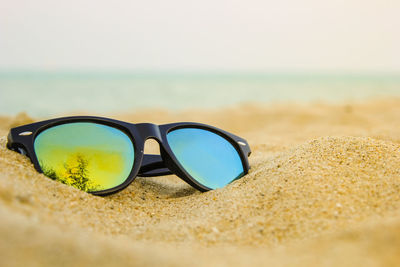 Close-up of sunglasses on beach