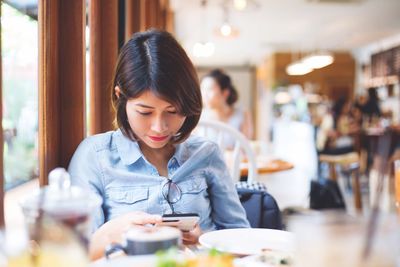 Close-up of woman holding coffee cup in restaurant