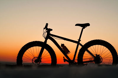 Silhouette bicycle against sky during sunset