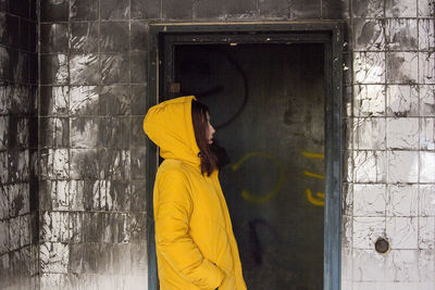 Rear view of woman standing against wall