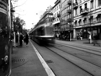 People on railroad tracks in city