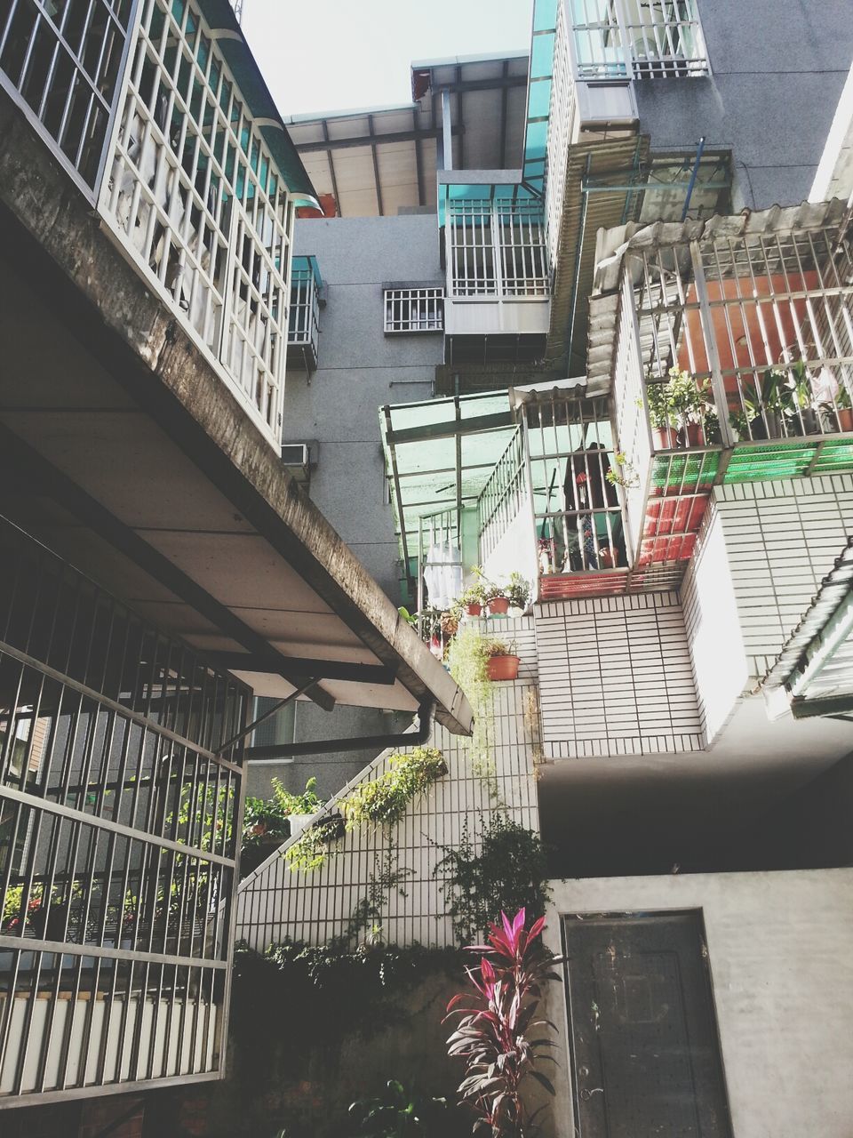 architecture, building exterior, built structure, low angle view, building, railing, residential building, balcony, residential structure, city, steps, staircase, steps and staircases, window, house, day, sunlight, modern, outdoors, no people