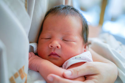 Close-up of baby boy lying on bed at home