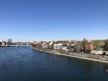 View of river and buildings against clear blue sky