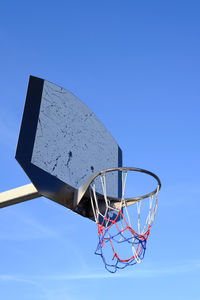 Low angle view of basketball hoop against clear blue sky