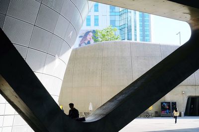 Low angle view of people walking on modern building