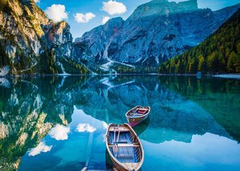 Scenic view of lake by mountains against sky