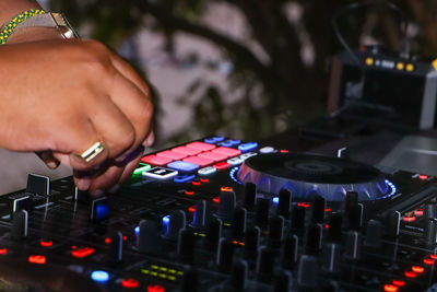 Cropped hand of dj playing music in club