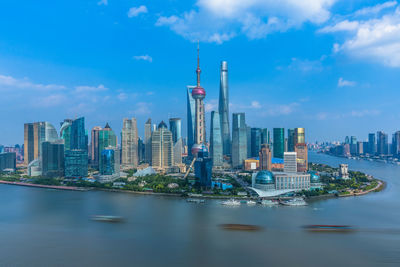 Modern buildings in city against cloudy sky