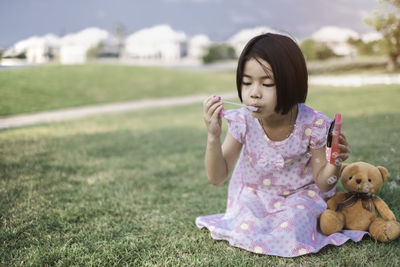 Portrait of a girl with toy on field