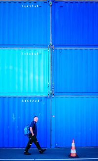 Full length of woman standing against blue sky