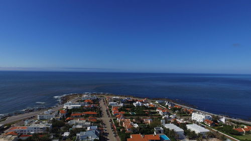 High angle view of townscape by sea against clear sky