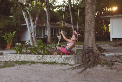 Woman with arms raised against trees