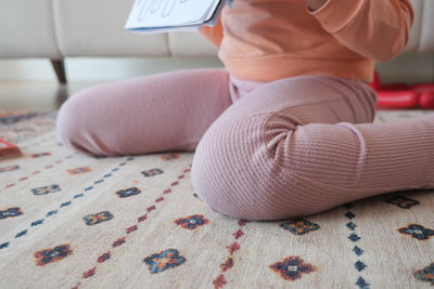Low section of woman reading book