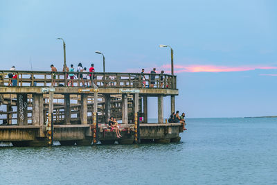 Bridge over sea against sky during sunset