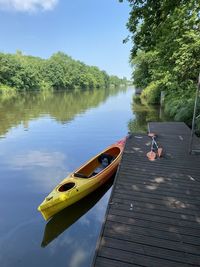 Reflection of man on boat in lake against sky