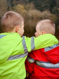 Rear view of siblings with arm around