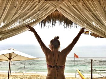 Rear view of woman standing on beach