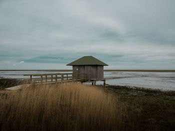 Lifeguard hut on beach against sky