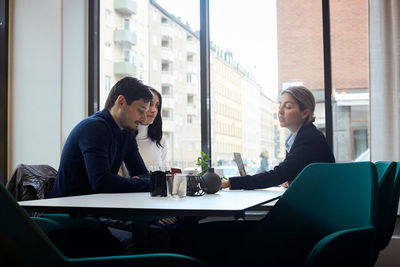 Female realtor advising couple sitting in office