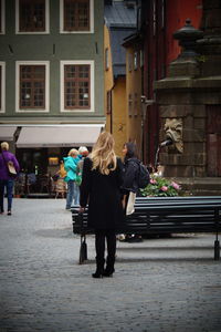 Rear view of people walking on street in city