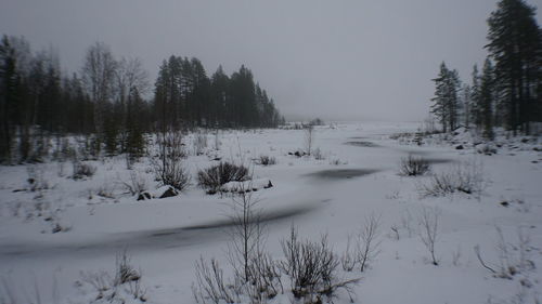 Scenic view of snow covered field against sky