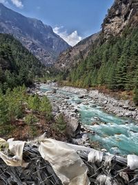 Scenic view of river by mountains against sky