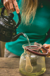 Woman prepares organic tea with dried herbs., in serra da mantiqueira, mg, brazil.
