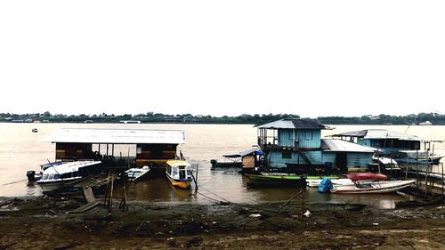 Boats moored in lake against buildings