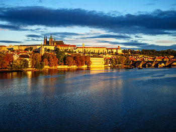 Scenic view of river by buildings against sky