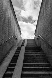 Low angle view of staircase amidst buildings against sky