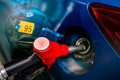 Car fueling at gas station. refuel fill up with petrol gasoline. petrol pump filling fuel nozzle 