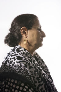 Portrait of young man looking away against white background