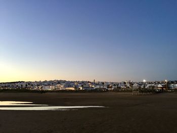 City by sea against clear blue sky