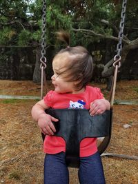 Full length of girl holding swing in park