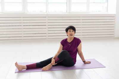 Full length of woman sitting on floor