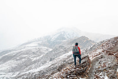 Rear view of man walking on mountain