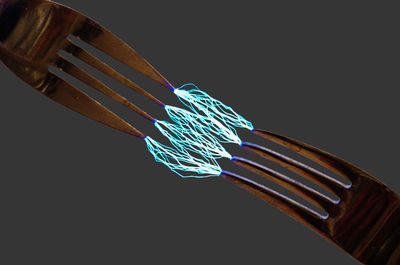 Low angle view of illuminated lighting equipment against black background