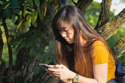 Teenage girl using mobile phone outdoors