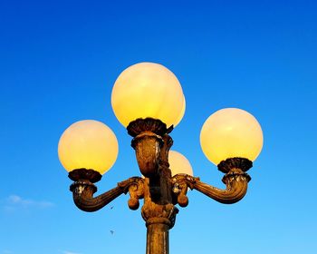 Low angle view of street light against blue sky