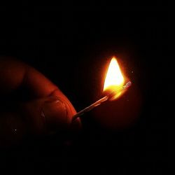 Close-up of lit candle in dark room