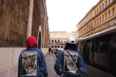 Rear view of people walking on street in city