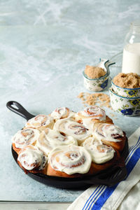 Close-up of cream on cinnamon buns in cooking pan at home